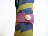 Luxury slim umbrella with bright chevron print, elegant black frame and striking gold handle by David David, a fashion accessories brand and print studio based in London England, specialising in bold geometric print