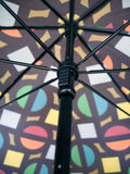 Luxury slim umbrella with bright roundel print, elegant black frame and striking gold handle by David David, a fashion accessories brand and print studio based in London England, specialising in bold geometric print