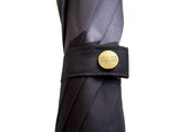 Luxury slim umbrella with stunning monochrome canopy design, elegant black frame and striking gold handle by David David, a fashion accessories brand and print studio based in London England, specialising in bold geometric print